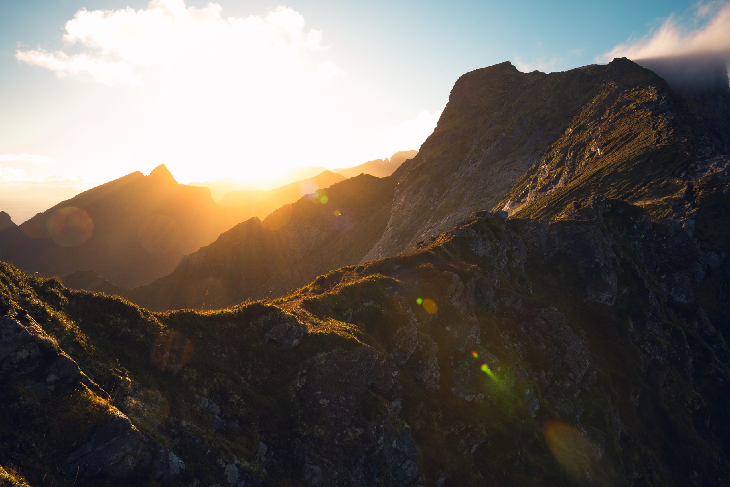 //editorapangeia.com.br/wp-content/uploads/2022/02/beautiful-horizontal-shot-of-the-rising-sun-and-high-rocky-mountains-under-the-cloudy-sky-scaled.jpg